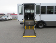 A 2020 Chevrolet Express cutaway bus with a ramp lowered for wheelchair access showing the interior seating area and handrails
