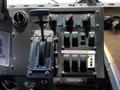 A control panel featuring various switches levers and indicators including a gear shift and multiple buttons labeled for different functions