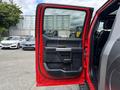 A red 2019 Ford F-150 truck door is open revealing a black interior with a silver handle and controls