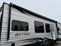 A 2021 Jayco Jay Flight travel trailer with a sleek silver exterior and large windows featuring the word OCTANE on the side