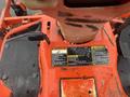 A close-up view of the control panel of a 2010 Kubota F3680 featuring warning labels and control levers