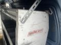 A Weather Guard storage box attached to a 2009 Ford Econoline van displaying signs of wear and tear with metal brackets and a white exterior