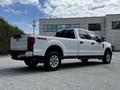 A white 2020 Ford F-350 Super Duty truck with a crew cab and four-wheel drive, showing the rear and passenger side view