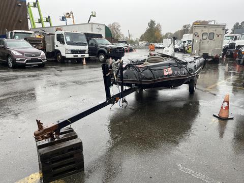 A 2009 ShoreLandr ANDER boat trailer with a black frame and a boat attached, featuring a license number C5 on the side and secured with ropes