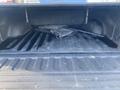 A 2017 RAM 1500 truck bed with a textured floor and scattered items including a rolled tarp and a metal pole