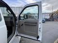 A 2008 Ford F-450 truck with an open driver's door revealing the interior door panel and controls