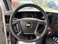 Steering wheel of a 2020 Chevrolet Express with a Chevrolet logo in the center and various dashboard controls visible behind it