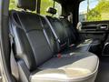 A spacious back seat of a 2022 RAM 3500 featuring black leather upholstery with stitching details and two seatbelts visible