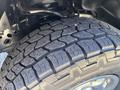 Close-up of a rugged tire from a 2016 Ford F-150 showcasing deep tread patterns designed for traction and off-road performance