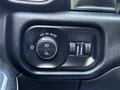 A control panel in a 2022 RAM 3500 featuring buttons and knobs for headlights fog lights and dashboard brightness adjustment