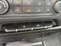 Close-up of the control panel of a 2016 GMC Sierra 1500 featuring climate control buttons and switches for various vehicle functions
