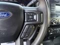 A 2019 Ford F-550 steering wheel with various control buttons for volume and media functions