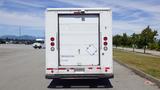 A white 2011 Ford Econoline cargo van viewed from the rear with a simple design and rear doors closed