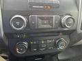 A close-up view of the control panel in a 2016 Ford F-150 featuring knobs for volume climate control and radio functions