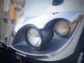 Close-up of the chrome front end of a 2016 International WorkStar 7500 featuring a large round headlight and a smaller amber marker light