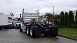 A 2019 Western Star Trucks 4900 with a silver body and a black chassis is parked with its rear facing the viewer