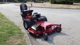 A red 2014 Ferris Mower ISX 800 with a seat and large rear tires features a cutting deck with blades visible in the front