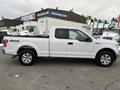 A white 2017 Ford F-150 with a crew cab and short bed parked in a lot featuring four-wheel drive and chrome accents