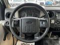 A close-up view of the steering wheel and dashboard of a 2009 Ford F-550 showing various gauges and controls