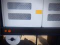 A close-up of the side of a 2007 Ford F-650 featuring a white panel with mesh cutouts and two orange indicator lights