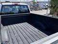 A 2016 Ford F-150 truck bed with a textured surface and a wheel well visible on the side