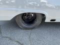 A close-up view of the black wheel and tire of a 1962 Ford F-100 with a rugged tire tread showing wear