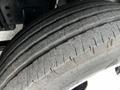 Close-up view of a worn tire from a 2018 Isuzu NPR showcasing visible tread wear and exposed rubber patterns