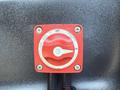 A red switch labeled with an off and on symbol mounted on a black surface