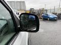 A 2017 Dodge Grand Caravan is visible, showcasing its side mirror with raindrops on the glass and a blurred vehicle in the background