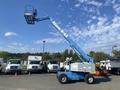 A 1997 Genie S-65 4X4 lift with an extended boom and basket on top, designed for aerial work and construction tasks