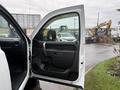 A white 2013 Chevrolet Silverado 3500HD with an open driver's side door showcasing the interior door panel and handle