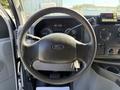 Steering wheel of a 2011 Ford Econoline with a Ford logo in the center and various dashboard controls visible on the right