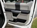 Inside view of a 2017 Ford F-450 Super Duty door panel featuring a beige and black design with a handle and a storage compartment
