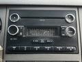 Dashboard of a 2016 Ford F-550 featuring a car stereo with buttons for AM FM CD and AUX inputs along with a digital display and volume control