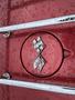 Close-up of the emblem on a 1970 Chevrolet Corvette featuring a crossed flags design with a red background and raindrops on the surface