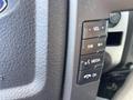 Close-up of the control panel in a 2012 Ford F-150 featuring buttons for volume media and phone functions