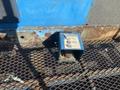 A blue control box with instructions mounted on a metal grate, showing signs of wear and rust on the surface