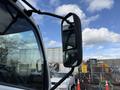 Side mirror of a 2014 Hino 195 truck reflecting a cloudy sky