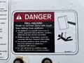 A safety warning sign for a 2013 International DuraStar detailing fall hazards and precautions for platform occupants