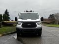 A white 2016 Ford Transit van facing forward with a black grille and a refrigerated unit on the roof