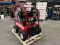 A red and black 2024 Magnum 4000 Hot Water Pressure Washer mounted on a wooden pallet with large wheels and a protective frame surrounding the engine and pressure components