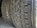 Close-up of a tire from a 2013 Chevrolet Express showing deep tread patterns and small debris embedded in the rubber surface