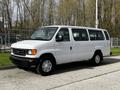 A white 2004 Ford Econoline van parked on a concrete surface with visible wheels and side doors
