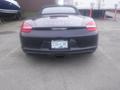 A black 2016 Porsche Boxster viewed from the rear showcasing its sleek design and distinctive branding on the trunk