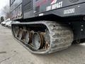 Close-up of a 2023 Prinoth Panther T6 showing its undercarriage and track system with grooved wheels for enhanced traction and stability