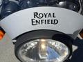 Close-up of the front headlight of a 2022 Royal Enfield Himalayan motorcycle featuring the logo prominently displayed on the headlight cowl