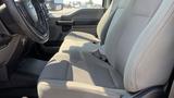 Interior view of a 2019 Ford F-550 showcasing a gray fabric front seat with seat belts and a steering wheel in the foreground