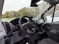 Interior view of a 2019 Ford Transit showing the dashboard steering wheel and gear shift with black upholstery and control panel