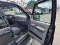 A black 2004 Ford Explorer Sport Trac with an open driver's door showing the interior and dashboard details