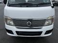 Front view of a 2002 Nissan Van featuring a white exterior and a prominent chrome grille with horizontal slats and headlights on either side